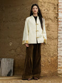Full-length outfit featuring the Yuanting ivory jacquard jacket, brown trousers and brown shoes.