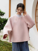 Blush pink Yuyan wool coat with a round neckline, asymmetric overlapping front, and curved hem
